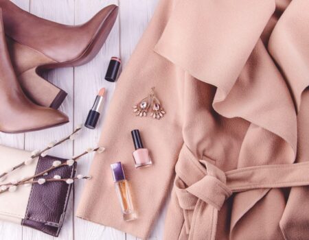 Accessoires de mode dans des tons de beige et marron disposés élégamment avec un manteau, créant une ambiance chaleureuse et coordonnée.