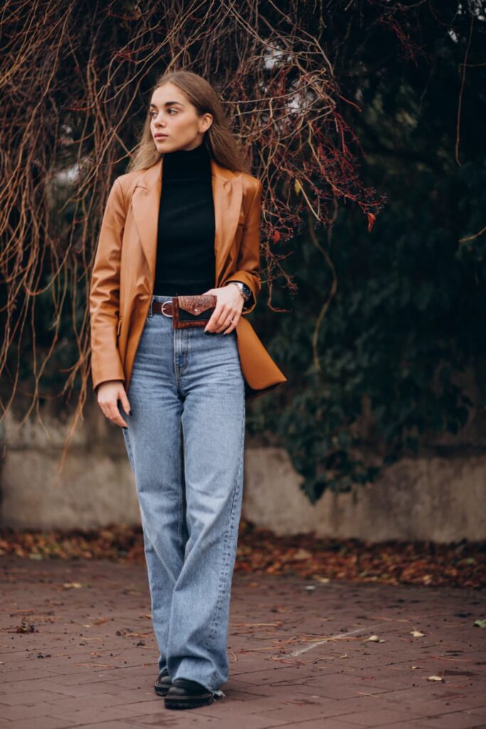 Femme en manteau brun sous un arbre.