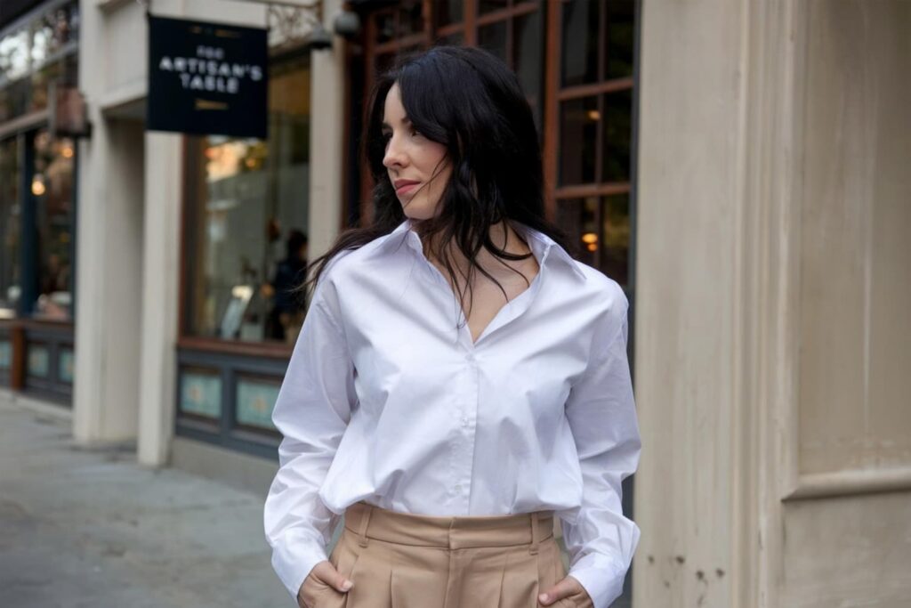 Femme en chemise blanche devant restaurant.