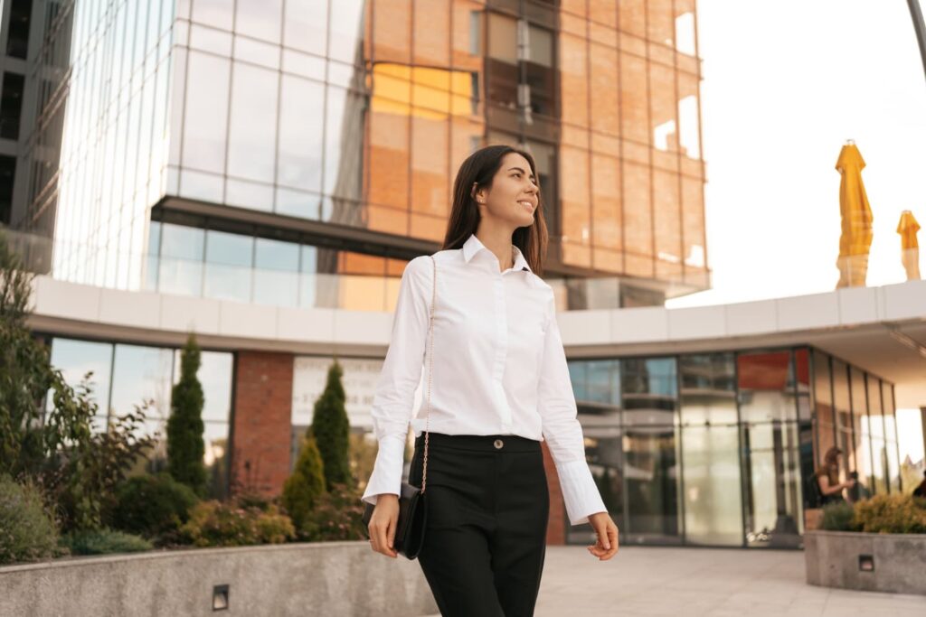 Femme marchant devant un immeuble moderne.