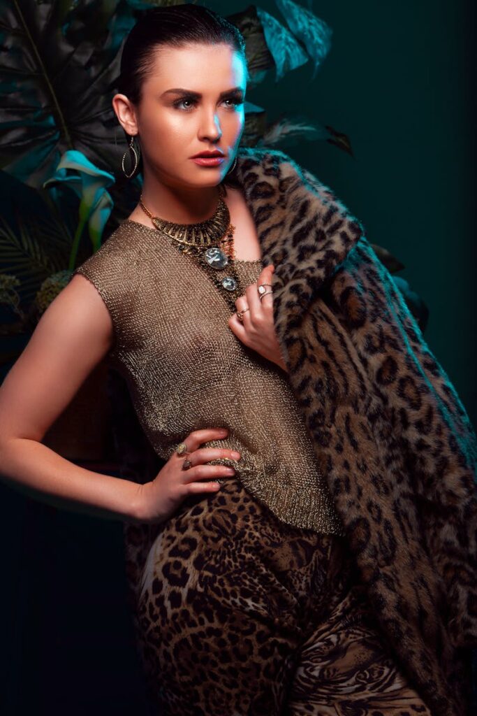 Fashion-forward woman in leopard print fur posing elegantly indoors.