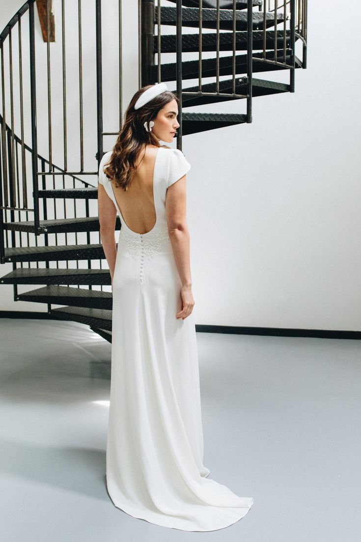 Femme en robe de mariée près d'un escalier.