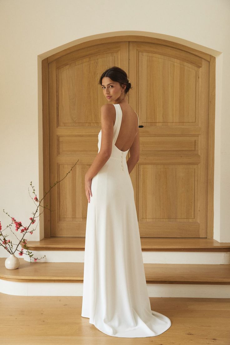 Femme en robe de mariée blanche élégante, intérieur boisé.