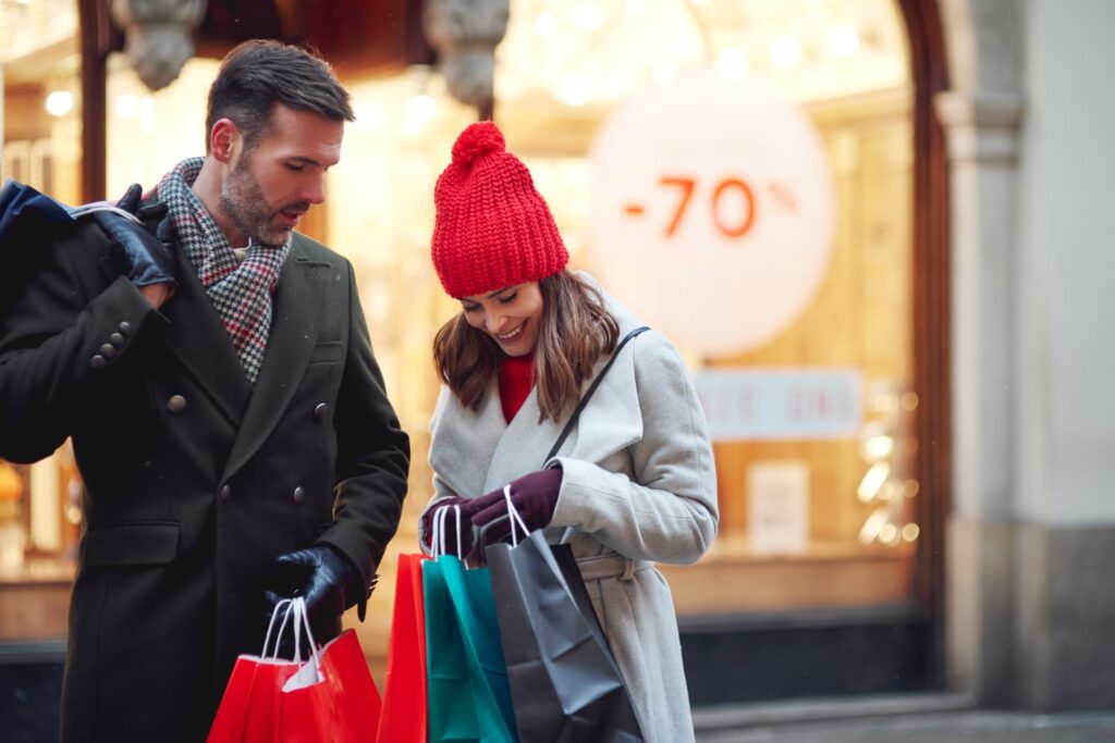 Couple souriant faisant les soldes d'hiver