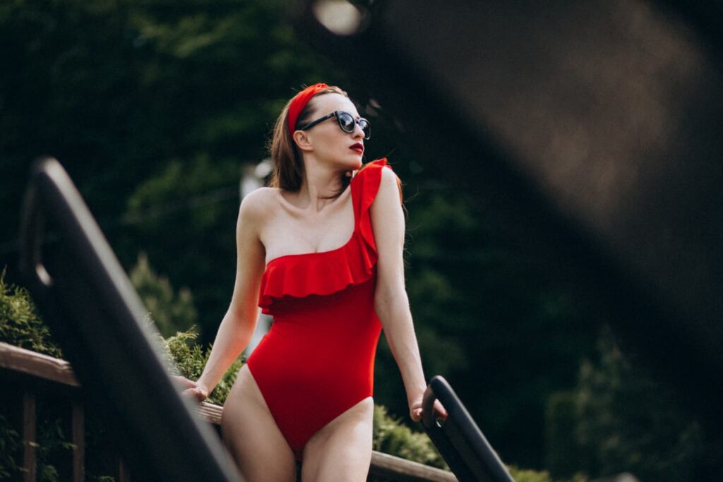 Femme en maillot rouge, lunettes de soleil.
