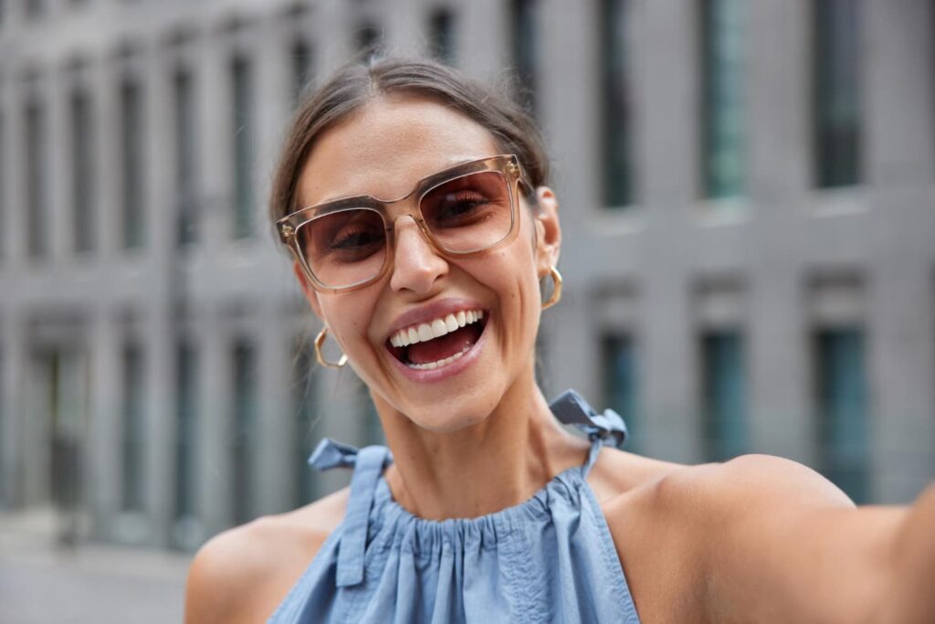 Femme souriante avec lunettes de soleil.