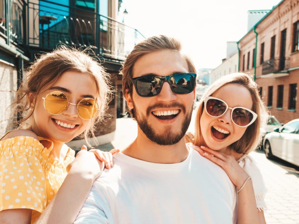 Amis souriants avec lunettes de soleil en extérieur.