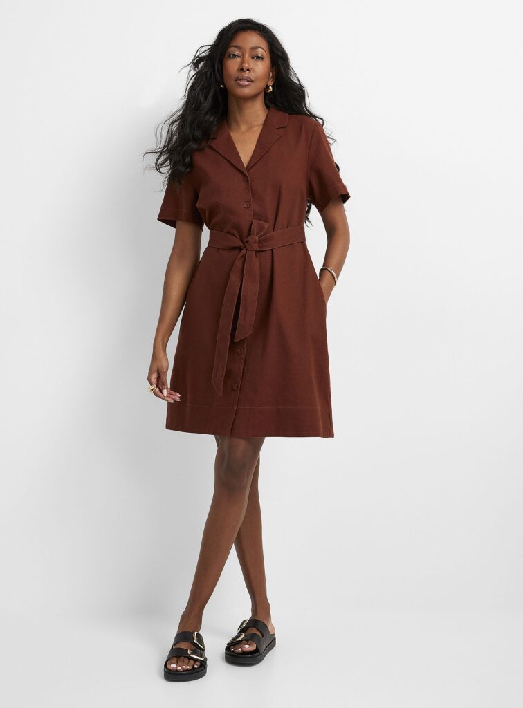 Femme portant robe marron ceinturée, sandales noires.
