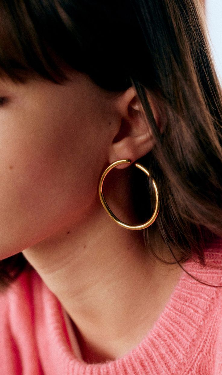 Boucle d'oreille dorée sur oreille.