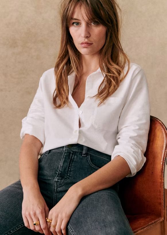 Person sitting wearing white shirt and jeans.
